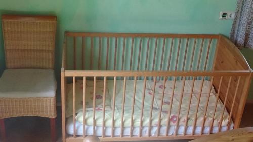 a wooden crib in a room with a bed at Ferienwohnungen Rosi in Kleblach