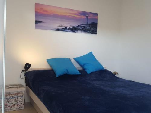 een bed met twee blauwe kussens in een slaapkamer bij BRAVAHOLIDAYS-260-Lotus-2 in Blanes