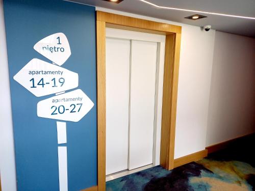a room with a door and signs on the wall at BALT Marynarska 8 in Sarbinowo