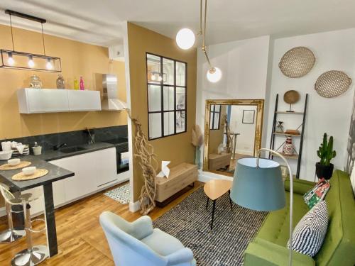 un salon avec un canapé vert et une table dans l'établissement Appartement quartier historique Orleans, à Orléans