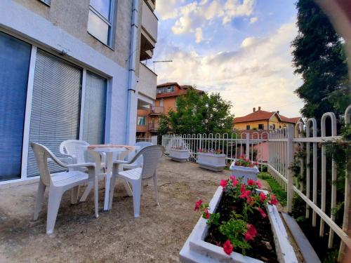 patio con tavolo, sedie e recinzione di Apartman Casa Lux a Vrnjačka Banja