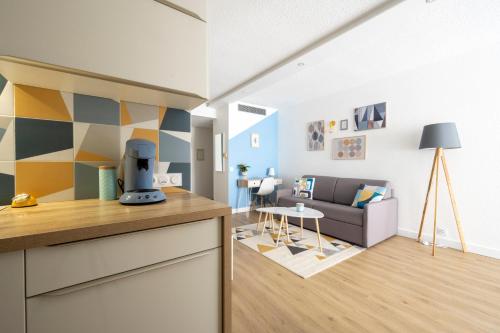 une cuisine et un salon avec un canapé dans l'établissement T2 cosy Port de plaisance Parking-wifi gratuit, à Rochefort