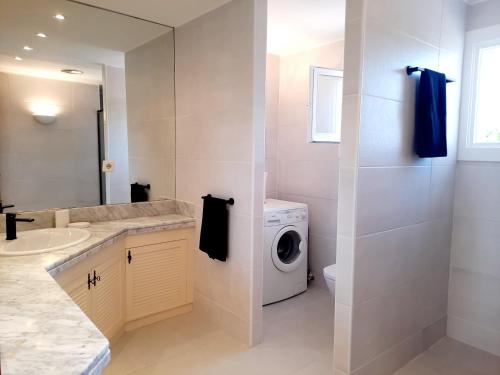 uma casa de banho com uma máquina de lavar roupa e uma máquina de lavar e secar roupa em Apartamento Vistas golf Bonmont em Bonmont Terres Noves