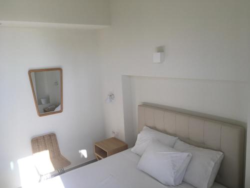 a bedroom with a bed with a mirror and a chair at Vourkari Village in Vourkarion