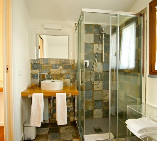 ボルゲリにあるAgriturismo Sant'Ubertoのバスルーム(ガラス張りのシャワー、シンク付)