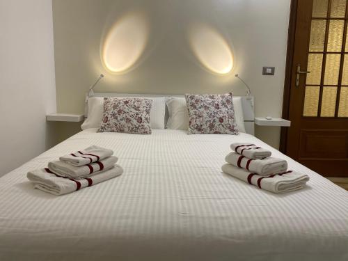 a bedroom with a bed with towels on it at Il Gatto sulla Luna, ai piedi delle Langhe in Narzole