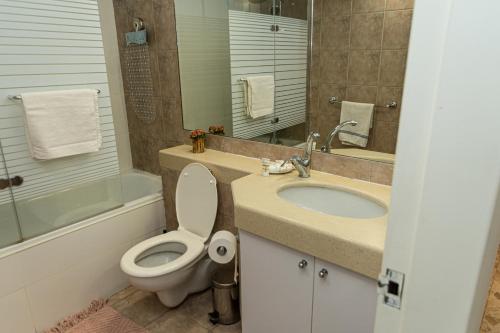 a bathroom with a toilet and a sink and a tub at ROYAL PARK -George in Eilat
