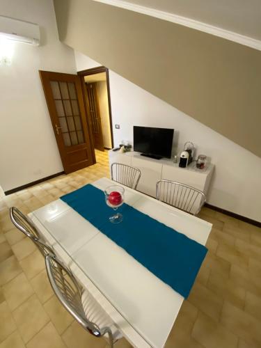 a room with a table and chairs and a television at Il Gatto sulla Luna, ai piedi delle Langhe in Narzole