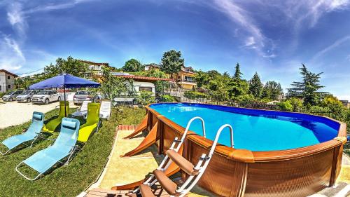 a large swimming pool with chairs and an umbrella at Villa Summer House in Saints Constantine and Helena