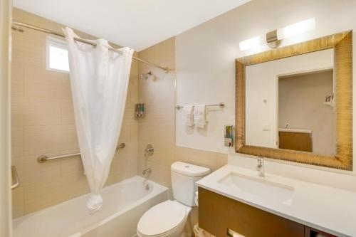 a bathroom with a toilet and a sink and a mirror at Hotel 414 Anaheim in Anaheim
