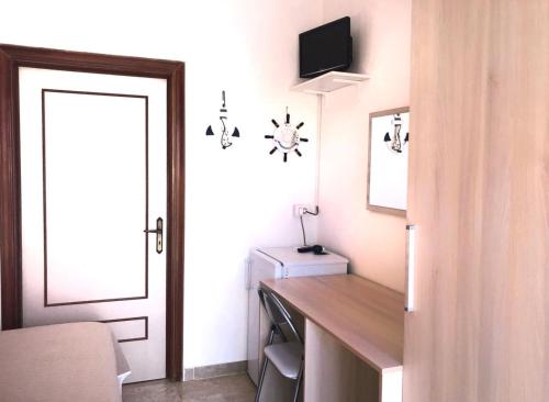 Pokój z biurkiem i drzwiami z telewizorem w obiekcie Dimora Il Girasole w mieście Torre San Giovanni Ugento