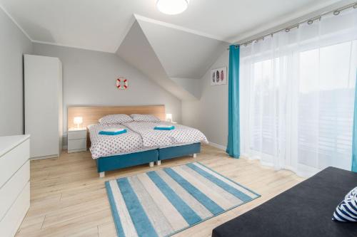 a bedroom with a bed and a large window at Plażowe Apartamenty Grzybowo in Grzybowo