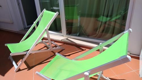 dos sillas verdes sentadas junto a una ventana en Big Sabaudia, en Sabaudia