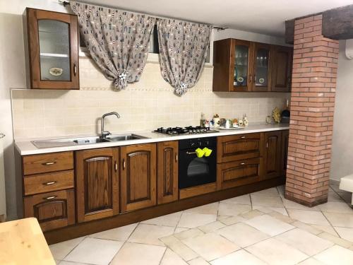 ガエータにあるMonolocale King AlMar con parcheggio autoの木製のキャビネットとコンロ付きオーブンを備えたキッチン