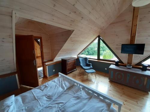 a room with a bed and a desk and a chair at Natura Apartamenty in Swaderki