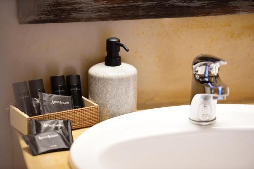 a bathroom sink with a soap dispenser next to it at Onar Hydra in Hydra