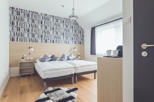 a bedroom with a bed and a wall with books at Smart Hotel in Körösladány