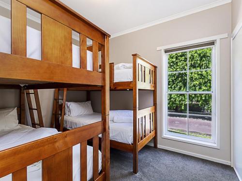 two bunk beds in a room with a window at Elizas Townhouse in Port Fairy