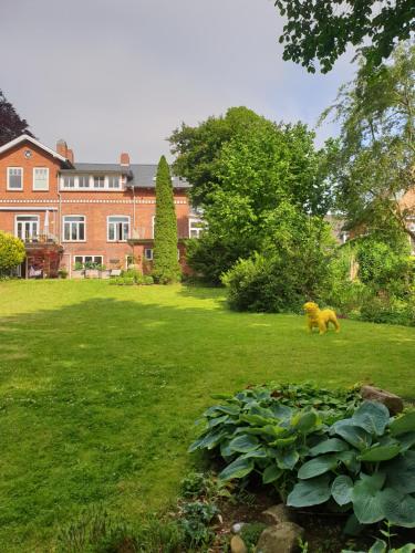 un oso caminando en el césped frente a una casa en Kieler Eiderparadies, en Flintbek