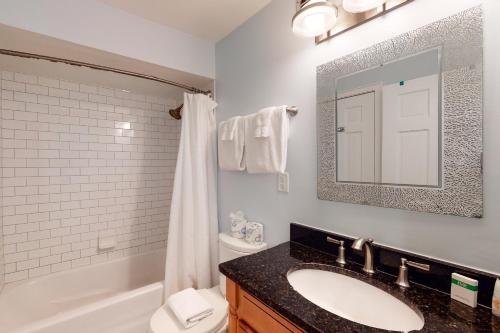 uma casa de banho com um lavatório, um WC e um espelho. em Seascape 3522 em Kiawah Island