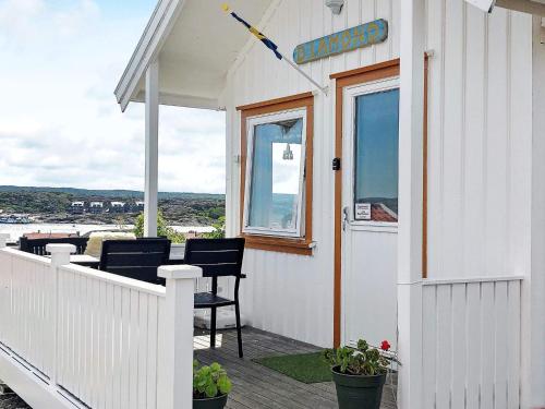 eine Veranda eines weißen Hauses mit Stühlen und einem Fenster in der Unterkunft 3 person holiday home in Gullholmen in Gullholmen
