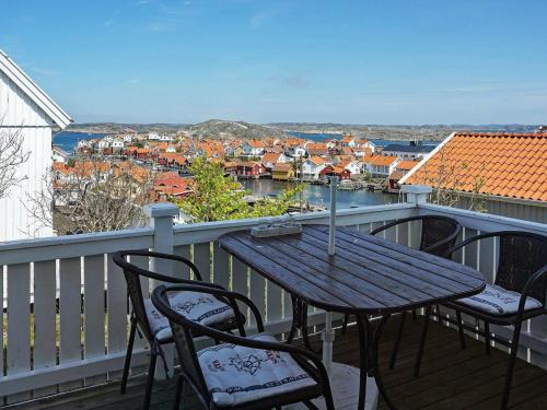 einen Holztisch und Stühle auf einem Balkon mit Aussicht in der Unterkunft 3 person holiday home in Gullholmen in Gullholmen