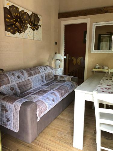 a couch in a room with a white table at B&B La Piazzetta in Castiglione dei Pepoli