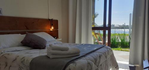 a bedroom with a bed with towels on it at Pousada Águas do Mampituba in Torres