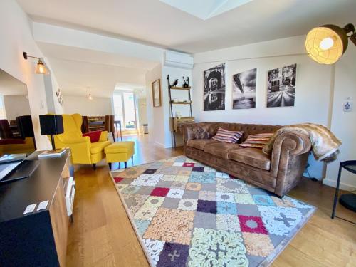 a living room with a brown couch and a rug at Unique apartment by MyPlaceForYou, in the center of Lisbon with views over the city and the Tagus river in Lisbon