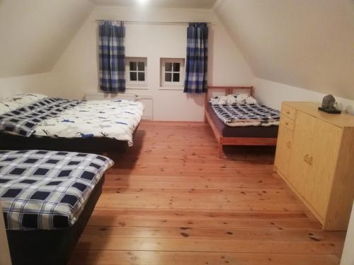 two beds in a room with wooden floors at Climb And Bike in Tisá
