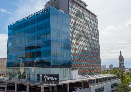 un grand bâtiment en verre avec un panneau sur celui-ci dans l'établissement Hotel Kavia Monterrey, à Monterrey