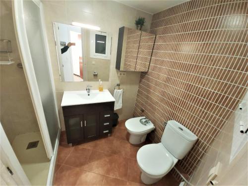 a bathroom with a toilet and a sink and a mirror at DIANA Apartamento con terraza muy cerca del mar in Pineda de Mar