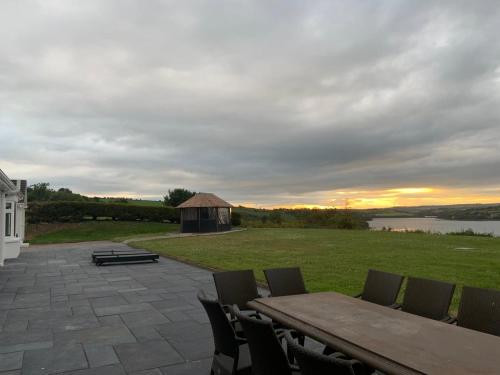 a patio with a table and chairs and a barn at Marina views, Kinsale, Hosted by Exquisite holiday homes, sleeps 20 in Kinsale