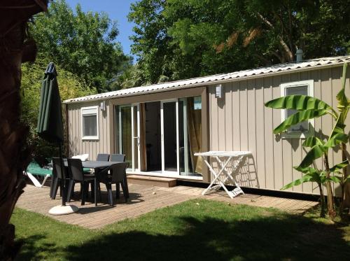 滨海阿热莱斯TOPSUN Argelès La Sirène 3 bedroom Max 4 adulte et 2 des ses enfants的一个带桌子的庭院和一座建筑
