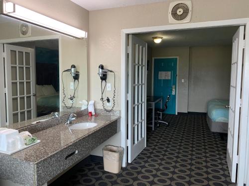 a hotel bathroom with a sink and a mirror at Travelodge by Wyndham San Antonio Downtown Northeast in San Antonio