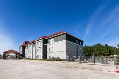 a large building with a fence in front of it at La Quinta by Wyndham Lumberton in Lumberton
