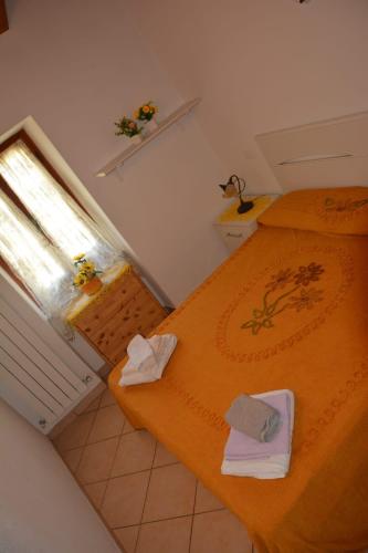 a small bedroom with two beds and a window at Agriturismo Ghirlanda Norma Rita in Carrodano Inferiore