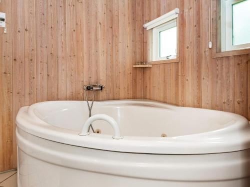 Hejlsにある6 person holiday home in Hejlsの木製の壁のバスルーム(白いバスタブ付)