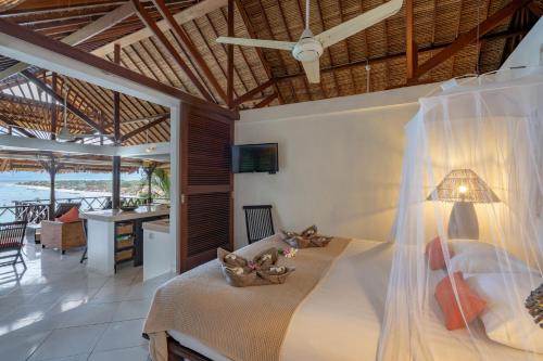 a bedroom with a bed in a room with a table at Villa Atas Lembongan in Nusa Lembongan