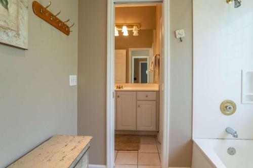 a bathroom with a tub and a sink and a mirror at Lloyd's Lodge at Davis Love Dr in Fripp Island