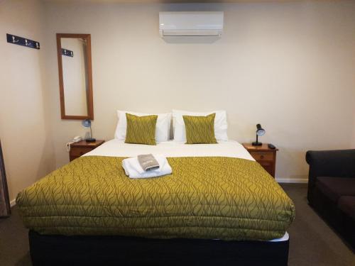 a hotel room with a bed with a book on it at Cranford Cottages and Motel in Christchurch