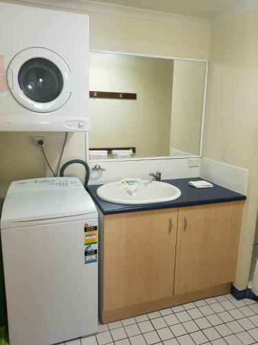 a bathroom with a sink and a mirror at Trinity Beach Club Holiday Apartments in Trinity Beach