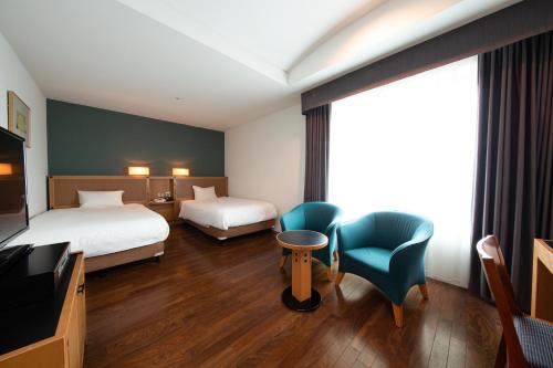 Habitación de hotel con 2 camas y TV en Hotel Nagoya Garden Palace, en Nagoya