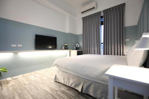 a bedroom with a bed and a tv on the wall at Manting Homestay in Hualien City