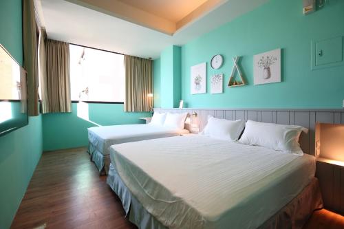 two beds in a room with blue walls at Manting Homestay in Hualien City