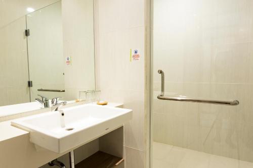 a white bathroom with a sink and a shower at Montana Premier Senggigi in Senggigi 
