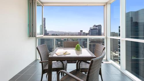 a dining room table with a view of a city at Oaks Brisbane Festival Suites in Brisbane