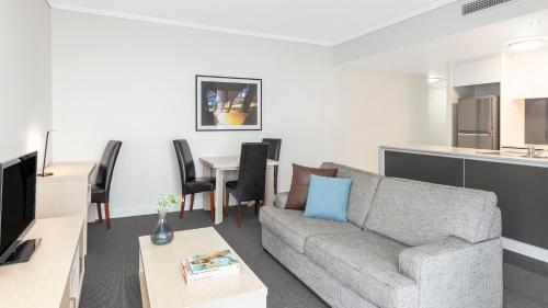 a living room with a couch and a table at Oaks Brisbane Festival Suites in Brisbane