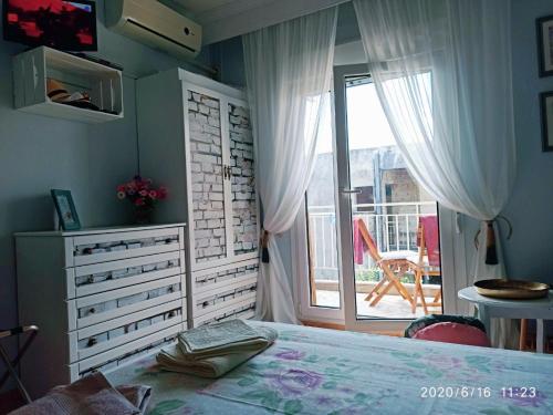 a bedroom with a bed and a sliding glass door at Apartment Marina 2 in Asprovalta