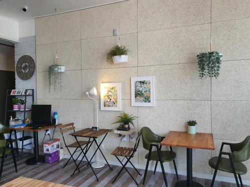 a restaurant with tables and chairs and a wall at Gyeongju BonghwangMansion in Gyeongju